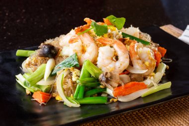 Restoranda ya da mutfak ortamında bir tabak kızarmış cam erişte manzarası..