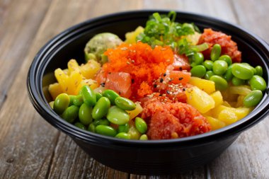 Somon, baharatlı ton balığı ve edamame içeren özel dürtme kasesi manzarası.