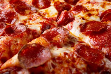Arka plan olarak pepperonili pizzanın yakın plan görüntüsü..