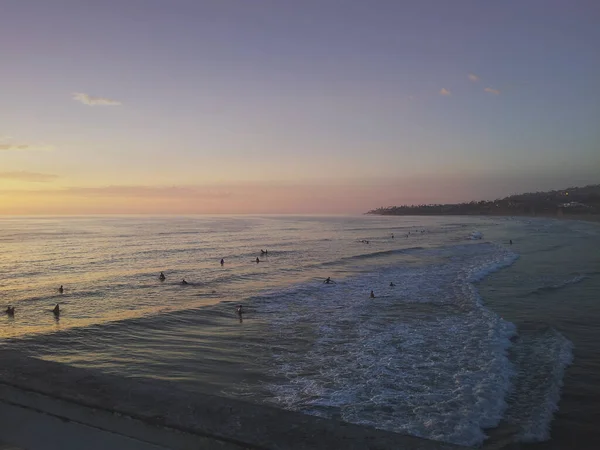 日没の間 カリフォルニア州サンディエゴの海岸線の眺め いくつかのサーファーは良い波を待っている — ストック写真