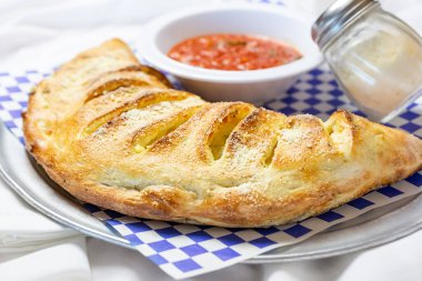 Bir tabak calzone manzarası, bir restoranda ya da mutfak ortamında.