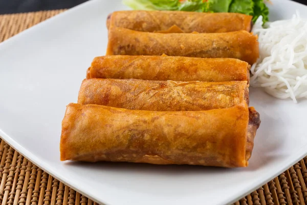 A view of a plate of egg rolls.