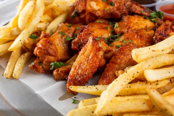 식당이나 주방에서 버펄로 날개와 감자튀김 특징인 식욕을 돋우는 접시의 — 스톡 사진