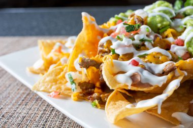 Çerçevenin sağ tarafından kesilmiş bir tabak karne asada nachos yakın çekim görüntüsü..