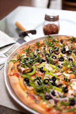 Et, sebze ve fesleğen soslu, bir restoranda ya da mutfak ortamında kırsal pizza..