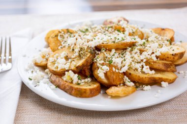 Bir tabak patates dilimi ve peynir manzarası..