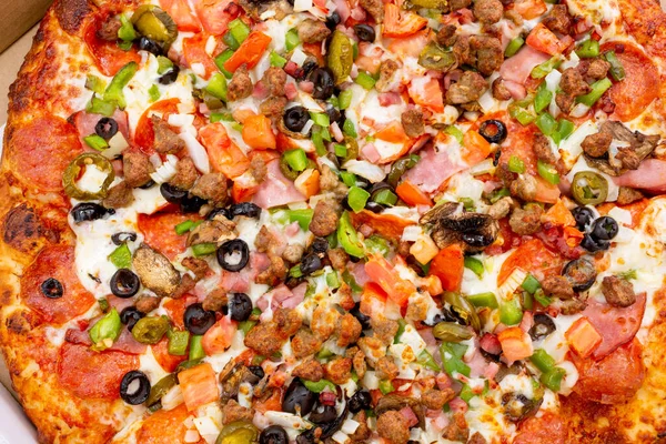 Bir et ve sebzeli pizzanın arka plan görüntüsü, bir karton kutunun içinde..