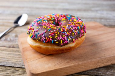 İçinde gökkuşağı parçacıkları olan çikolatalı donut manzarası..
