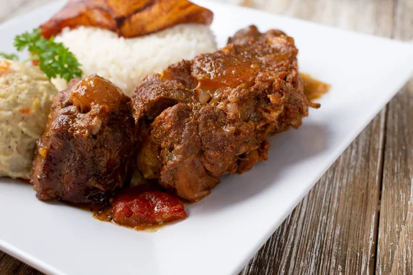A view of a plate of Caribbean style oxtail.