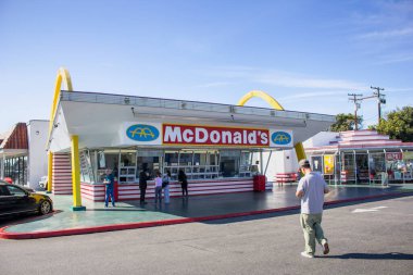 Downey, California, ABD - 01-31-2020: Halen faaliyet gösteren en eski McDonald 's fast food restoranının tezgahından yemek sipariş eden insanların manzarası ve arka plandaki vintage tabelası.