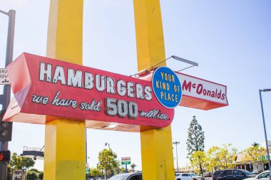 Downey, California, ABD - 01-31-2020: Halen faaliyet gösteren en eski ikinci McDonald 's fast food restoranında klasik bir McDonald' s sokak tabelasının manzarası. 