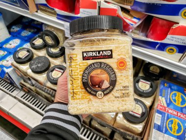 Alhambra, California / ABD - 01 / 31 / 2020: Bir el yerel bir Costco 'da sergilenen parmesan reggiano peyniri rendelenmiş bir konteynırı tutuyor.