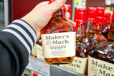 Moreno Vadisi, Kaliforniya, ABD - 02-06-2020: Bir el yerel bir markette sergilenmekte olan Maker 's Mark Whisky şişesini tutuyor.