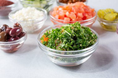 Diğer malzemelerin yanı sıra cam bir bardak tabbouleh manzarası..