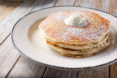 Üstünde çırpılmış tereyağı olan bir tabak krep manzarası..