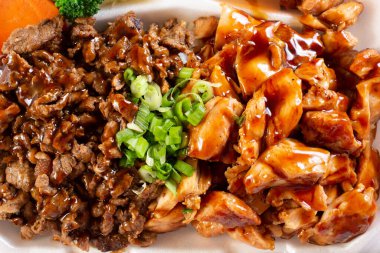 Biftek ve tavuklu teriyaki içeren bir konteynır manzarası..