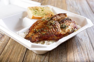 Beyaz pirinç üzerine ızgara tilapia manzarası, paket köpük kabının içinde..