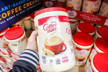 Tustin, California, United States - 02-08-2020: A hand holds a container of Nestle Coffee Mate instant coffee on display at a local big box grocery store. 