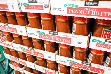 Tustin, California/United States - 02/08/2020: A view of several jars of Kirkland Signature organic creamy peanut butter on display at a local Costco.