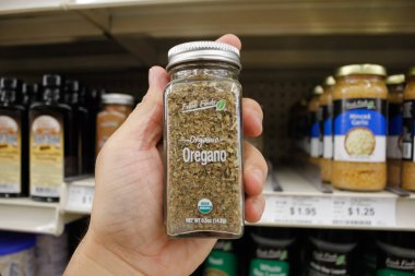 Long Beach, California, ABD - 02-12-2020: Bir el yerel Big Lots 'da sergilenmekte olan bir kavanoz taze bulunan organik Oregano' yu tutuyor.