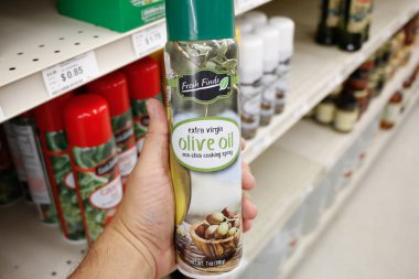 Long Beach, California, Amerika Birleşik Devletleri - 02-12-2020: Bir el, yerel bir Big Lots 'ta sergilenmekte olan ekstra bakire zeytinyağı konservesini tutuyor.