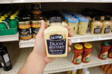 Long Beach, California / ABD - 02 / 12 / 2020: Bir el, yerel bir Big Lots mağazasında sergilenen Taze Bulgular Dijon Hardal şişesini tutuyor.