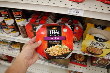 Long Beach, California / ABD - 02 / 12 / 2020: Bir el yerel bir bakkalda sergilenen Tayland yapımı Pad Thai erişte seti paketini tutuyor.