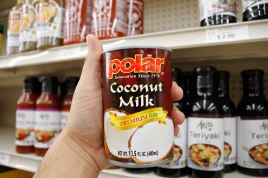 Long Beach, California / ABD - 02 / 12 / 2020: Yerel bir bakkalda sergilenen bir kutu MW Polar Hindistan cevizi sütü bir elde tutuluyor.
