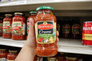 Long Beach, California / ABD - 02 / 12 / 2020: Bir el, yerel bir bakkalda sergilenmekte olan Bertolli marinara sosu kavanozunu tutuyor.