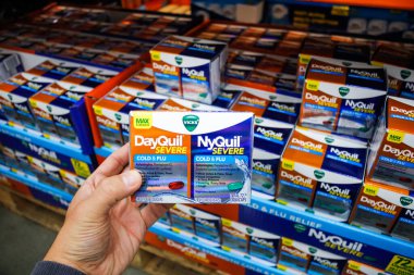 Garden Grove, California / ABD - 02 / 13 / 2020: Bir el Vicks DayQuil Severe ve NyQuil Severe karışımını yerel bir büyük market vitrininde tutuyor.
