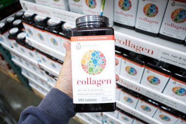 Garden Grove, Kaliforniya / ABD - 02 / 13 / 2020: Bir el, yerel büyük bir market vitrininde bir şişe YouTheory kolajeni tutuyor.