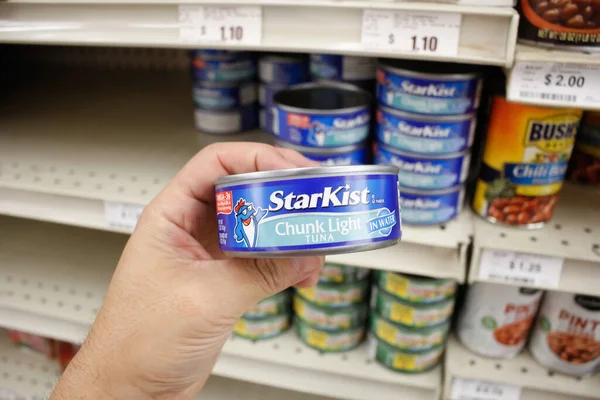 Long Beach, California, ABD - 02-12-2020: Bir el yerel bir markette sergilenmekte olan bir kutu StarKist ton balığını tutuyor.