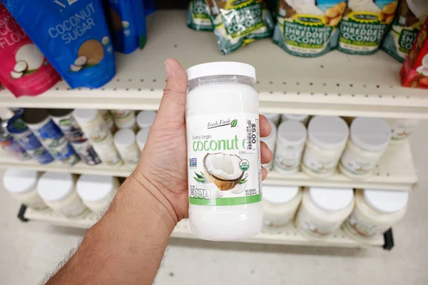 Long Beach, California, Amerika Birleşik Devletleri - 02-12-2020: Bir el, yerel Big Lots 'da sergilenmekte olan bir kavanoz Taze Bulgular Ekstra Bakire Hindistan cevizi yağı' nı tutuyor.