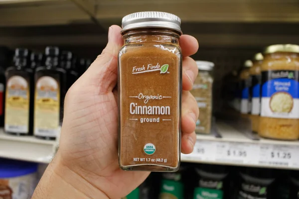 Long Beach, California / ABD - 02 / 12 / 2020: Bir el, yerel bir Büyük Lot 'ta sergilenen Taze Bulanlar Organik Zemin Tarçın kavanozunu tutuyor.