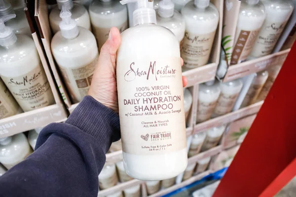 Garden Grove, Kaliforniya / ABD - 02 / 13 / 2020: Bir el yerel büyük bir markette sergilenmekte olan bir şişe Shea Nemini% 100 Virgin Coconut Oil Daily Hydration Şampuanı tutuyor.