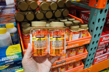 Alhambra, California / ABD - 02 / 19 / 2020: Bir el yerel bir Costco 'da sergilenmekte olan Kirkland İmza Ibuprofen IB tabletlerinin çoklu paketini tutuyor.