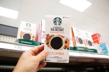 Alhambra, California, ABD - 02-19-2020: Yerel bir bakkalda sergilenmekte olan bir paket Starbucks Via Anında kahvesini tutan bir el.