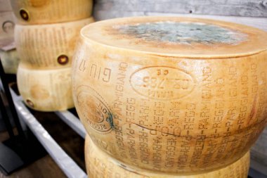 Los Angeles, Kaliforniya / ABD - 02 / 23 / 2020: Yerel bir İtalyan marketinde sergilenen Parmigiano Reggiano peynirinin çok sayıda büyük tekerleğine yakından bakmak.