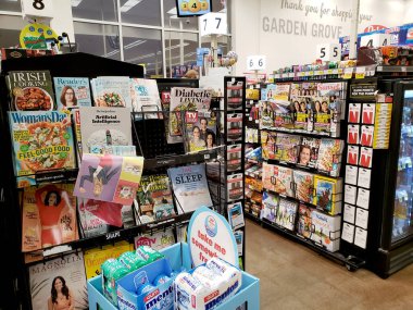 Garden Grove, California, United States - 03-16-2020: A view several options of impulse entertainment magazines, on display at the checkout lane of a local grocery store.