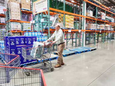 Los Angeles, Kaliforniya, ABD - 07-22-2020: Kirkland İmza kağıt havlu paketini taşıyan yaşlı bir adamın görüntüsü, yerel bir Costco 'da görüldü..