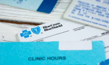 Los Angeles, California, ABD - 02-06-2020: BlueCross BlueShield 'dan bir kartın yer aldığı ahşap bir yüzey üzerindeki çok sayıda tıbbi üyelik kartının görüntüsü.