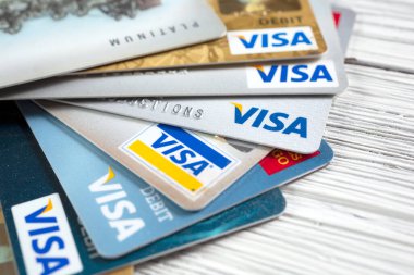 Los Angeles, California, United States - 02-06-2020: A closeup view of several Visa credit cards spread in a fan configuration on a wooden surface.