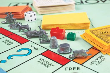 Los Angeles, California, ABD - 05-07-2020: Genellikle oyun sırasında kullanılan jetonlar, kartlar ve oyun parçalarının yer aldığı bir Monopoly oyun tahtası manzarası.