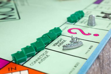 Los Angeles, California, ABD - 05-07-2020: Monopoly oyun tahtasının bir parçası olan birkaç yeşil ev parçasıyla çevrili Vermont Bulvarı 'na iniş yapan savaş gemisinin görüntüsü.