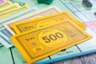 Los Angeles, California, ABD - 05-07-2020: Bir Monopoly masa oyunu setindeki renkli koordine para biriminin çeşitliliğinin yakın görüntüsü.