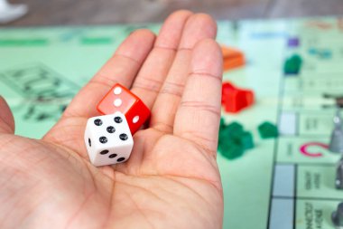 Los Angeles, Kaliforniya / ABD - 05 / 07 / 2020: Monopoly maçında bir çift zar tutan bir elin görüntüsü.