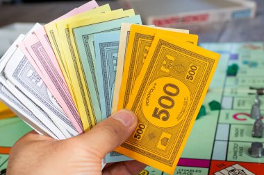 Los Angeles, Kaliforniya / ABD - 05 / 07 / 2020: Monopoly oyununun bir parçası olan Monopoly nakit parasının el ele tutuşması.