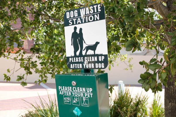 A view of a public dog waste station near a park.