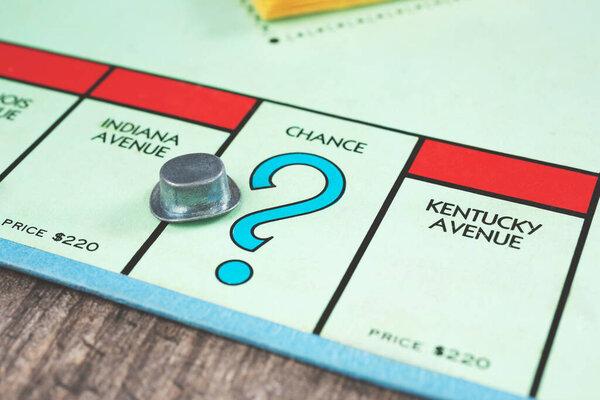 Los Angeles, California, United States - 05-07-2020: A view of the top hat token landing on the Chance square of a Monopoly game board.