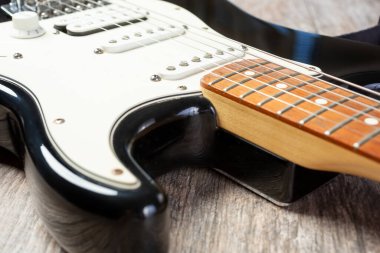 Siyah ve beyaz elektro gitarın boyun ve vücut görüntüsü.